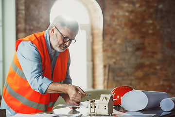 Image showing Close up of male architect-engineer making a model of house