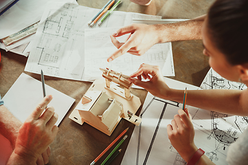 Image showing Foreman or achitect shows house, office or store design plans to a young couple