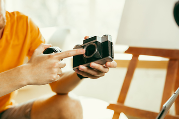 Image showing Caucasian male blogger with camera recording video review of gadgets at home