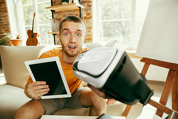 Image showing Caucasian male blogger with camera recording video review of gadgets at home