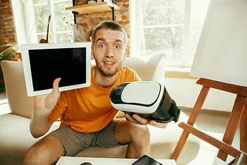 Image showing Caucasian male blogger with camera recording video review of gadgets at home