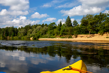 Image showing Yellow boat ride by the river.