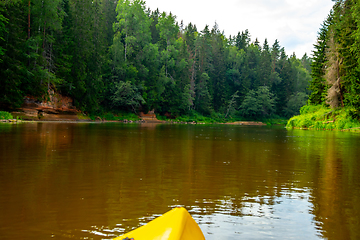 Image showing Yellow boat ride by the river.