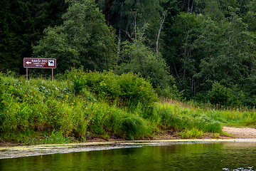 Image showing Green grass and forest on the river bank.