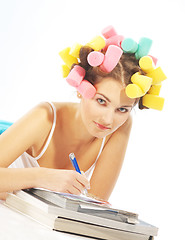 Image showing A writing woman in hair curles