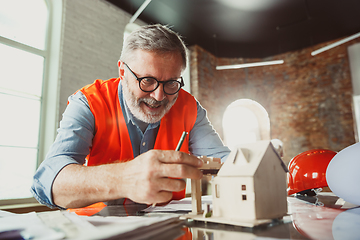 Image showing Close up of male architect-engineer making a model of house