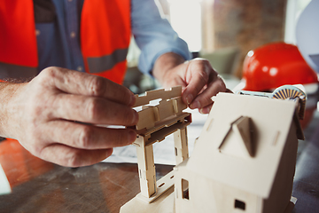 Image showing Close up of male architect-engineer making a model of house