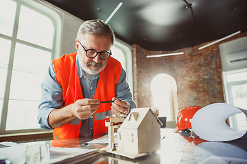 Image showing Close up of male architect-engineer making a model of house