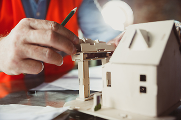 Image showing Close up of male architect-engineer making a model of house