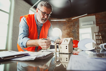 Image showing Close up of male architect-engineer making a model of house