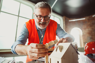 Image showing Close up of male architect-engineer making a model of house