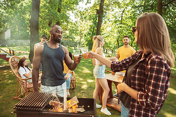 Image showing Happy friends are having beer and barbecue party at sunny day