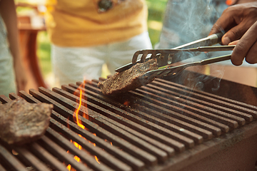 Image showing Close up of meat grilling, barbecue, summer lifestyle