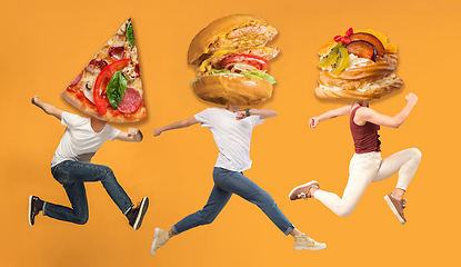 Image showing Fast food concept. Young people running on orange background