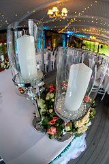 Image showing Candles in candlestick and flowers on wedding table