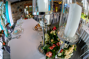 Image showing Candles in candlestick and flowers on wedding table