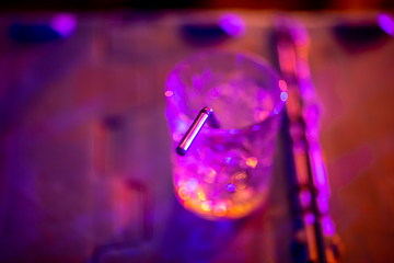 Image showing Glass of cocktail in abstract lights