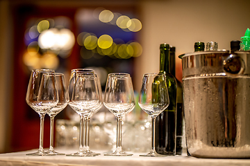 Image showing Wine glasses, bottles and ice bucket on table