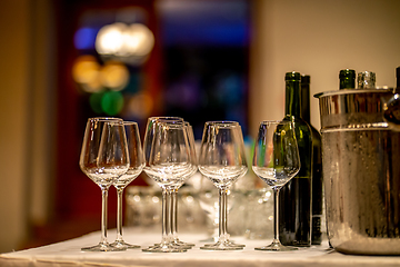 Image showing Wine glasses, bottles and ice bucket on table