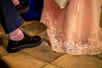 Image showing Bride and groom legs on floor