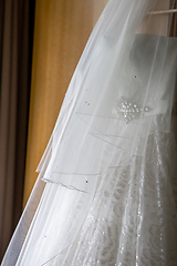 Image showing Bridal dress hanging at wooden closet