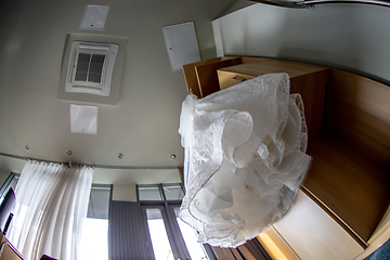 Image showing Bridal dress hanging at wooden closet