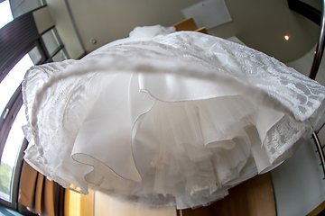 Image showing Bridal dress hanging at wooden closet