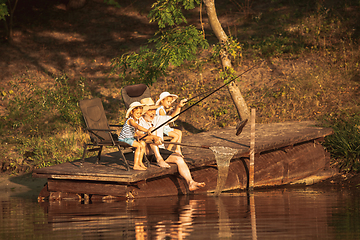 Image showing Cute little girls and their granddad are on fishing at the lake or river