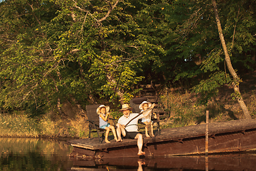 Image showing Cute little girls and their granddad are on fishing at the lake or river