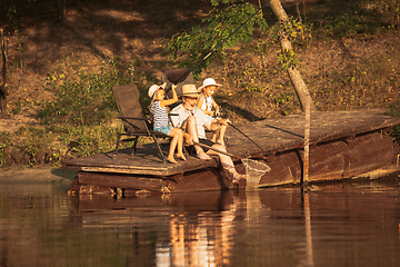 Image showing Cute little girls and their granddad are on fishing at the lake or river