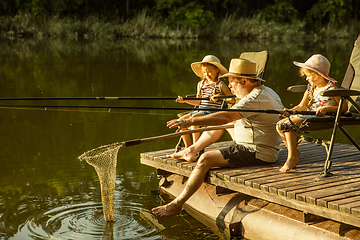 Image showing Cute little girls and their granddad are on fishing at the lake or river