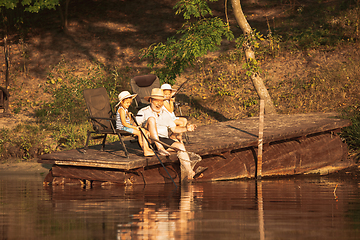 Image showing Cute little girls and their granddad are on fishing at the lake or river