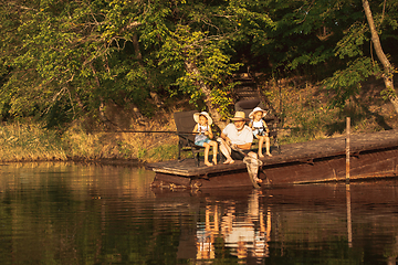 Image showing Cute little girls and their granddad are on fishing at the lake or river