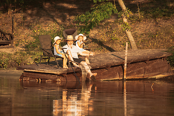 Image showing Cute little girls and their granddad are on fishing at the lake or river