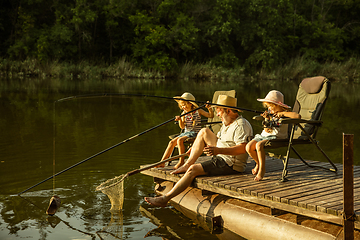 Image showing Cute little girls and their granddad are on fishing at the lake or river