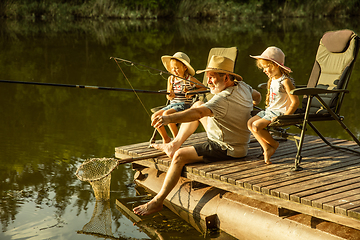 Image showing Cute little girls and their granddad are on fishing at the lake or river