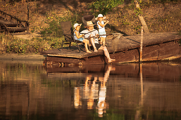 Image showing Cute little girls and their granddad are on fishing at the lake or river