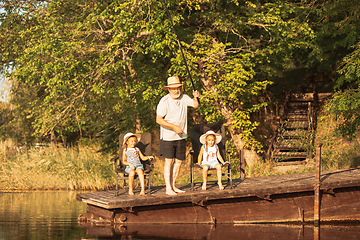 Image showing Cute little girls and their granddad are on fishing at the lake or river