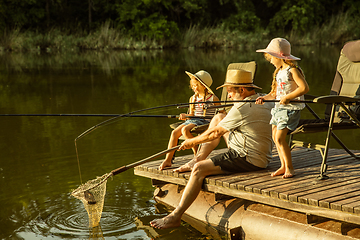 Image showing Cute little girls and their granddad are on fishing at the lake or river