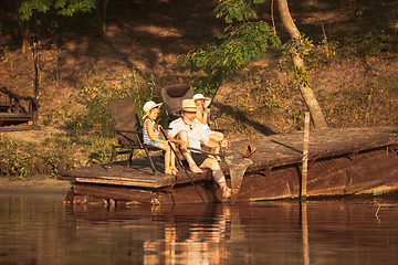 Image showing Cute little girls and their granddad are on fishing at the lake or river