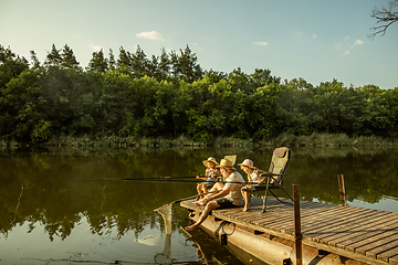 Image showing Cute little girls and their granddad are on fishing at the lake or river