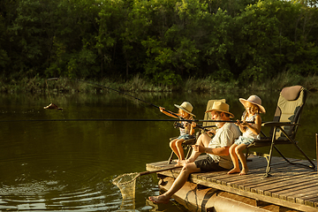 Image showing Cute little girls and their granddad are on fishing at the lake or river