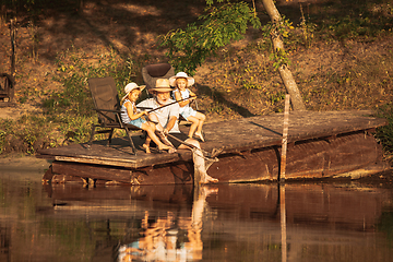 Image showing Cute little girls and their granddad are on fishing at the lake or river