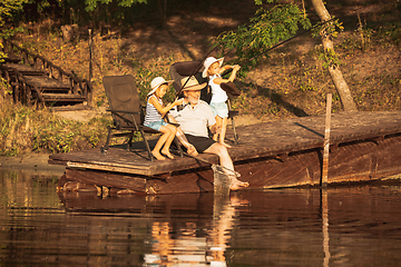 Image showing Cute little girls and their granddad are on fishing at the lake or river