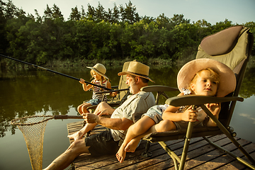 Image showing Cute little girls and their granddad are on fishing at the lake or river