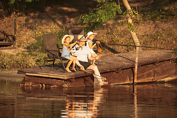 Image showing Cute little girls and their granddad are on fishing at the lake or river