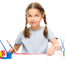 Image showing Little girl is painting with gouache