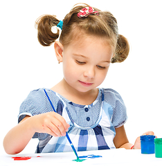 Image showing Little girl is painting with gouache