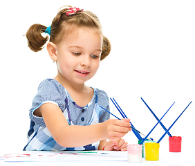 Image showing Little girl is painting with gouache