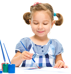 Image showing Little girl is painting with gouache